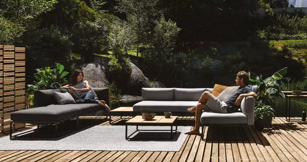 Abendliche Terrasse mit beleuchtetem rotem Sonnenschirm Sitzecke mit grauen Sitzpolstern