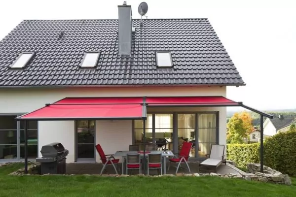 Terrasse mit Pergolamarkise Rote Pergola Markisen über dem Sitzbereich eines Hauses