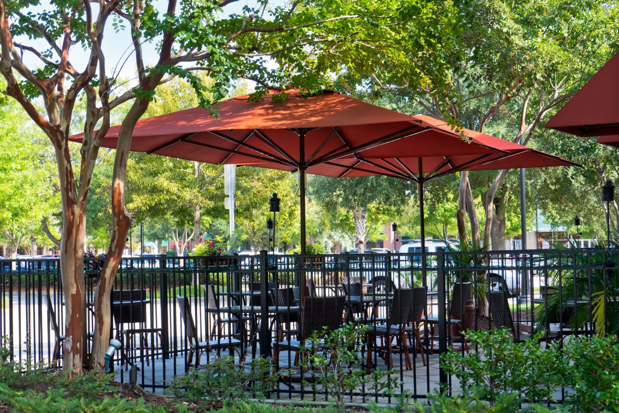 Abendliche Terrasse mit beleuchtetem rotem Sonnenschirm Orange Sonnenschirme im Gastrobereich