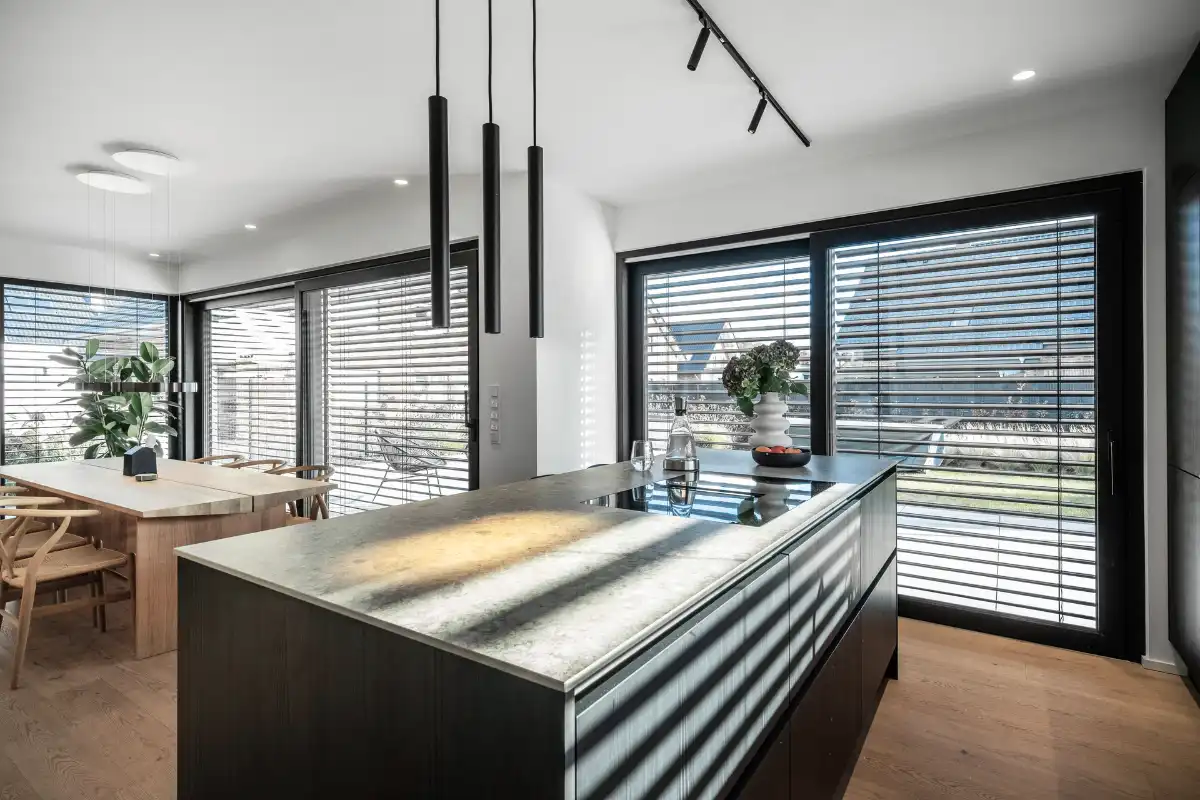 Moderner offener Wohn- und Essbereich mit dunklen Rollläden