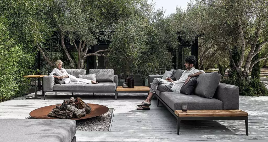 Abendliche Terrasse mit beleuchtetem rotem Sonnenschirm Graue Outdoor Sofas